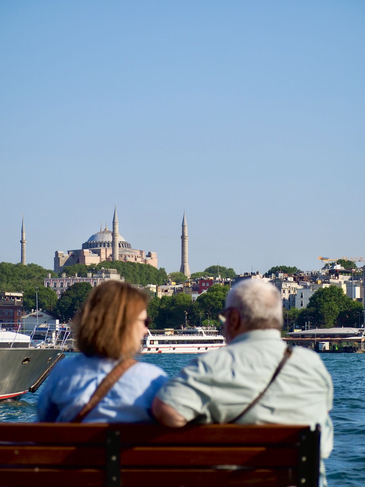 An elderly couple on a bench overlooking the Bosphorus and Hagia Sophia